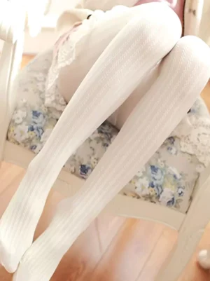 White elegant ribbed Lolita tights with vertical stripe texture worn with classic lace skirt indoor side view showcase