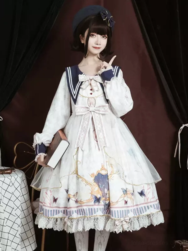 White sailor academic lolita OP dress three-quarter front view with big front bow, vintage print skirt, layered ruffle lace hem detail