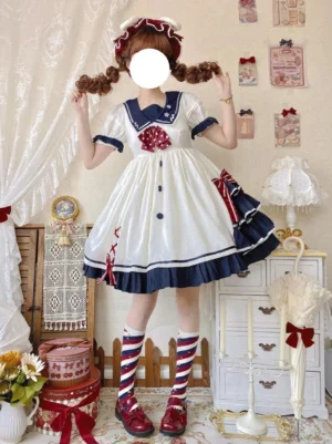 white sailor sweet lolita dress with navy collar and red polka dot bow front view on model wearing vintage indoor boutique setting