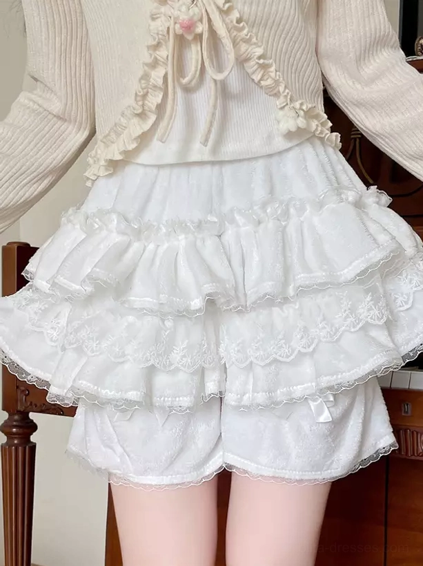 White multi-layer lace ruffled Sweet Lolita bloomers with velvet fabric and decorative hem bow, close-up front view showing detailed ruffle construction