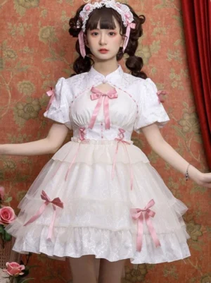 White Sweet Lolita dress three-quarter front angle showcasing stand collar, layered tulle skirt, and decorative elements with pink hair accessories against vintage floral curtain backdrop