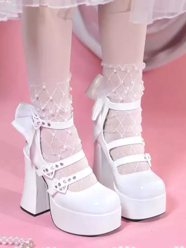 White sweet lolita chunky heel pumps with dual ankle straps and back bow, front low-angle view on model wearing pearl lace sheer socks against pink background