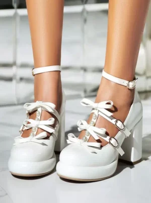 White patent leather sweet lolita pumps with bow embellishments and round toe, direct front view showcasing chunky block heel and glossy finish