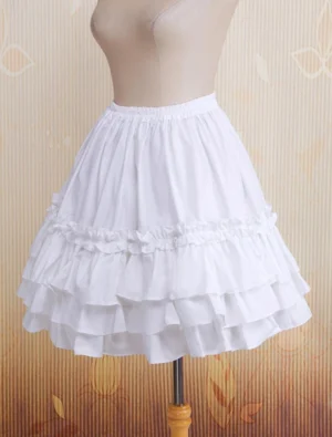 Three-quarter left side view of white frilly lolita skirt on dress form, displaying gathered elastic waist and double-layered ruffled hem structure in pure white cotton