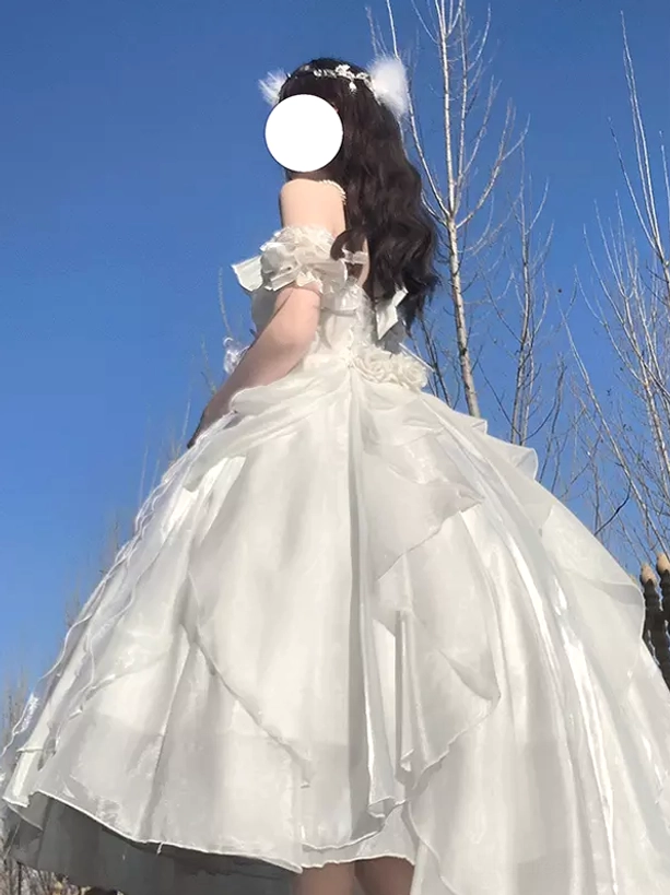 White satin lolita dress back view with ruffled off-shoulder construction and dimensional 3D flower details outdoor sky photography aesthetic