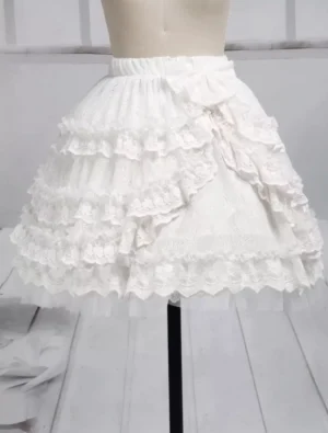 Pure white tiered tulle lolita short skirt with multi-layer lace ruffles and side bow, left front three-quarter view on dress form, classic lolita fashion design with scalloped hem details