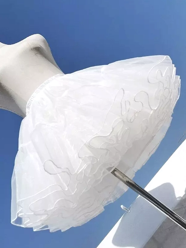 White tulle petticoat close-up side angle detail showing layered ruffled hem and sheer tulle fabric texture