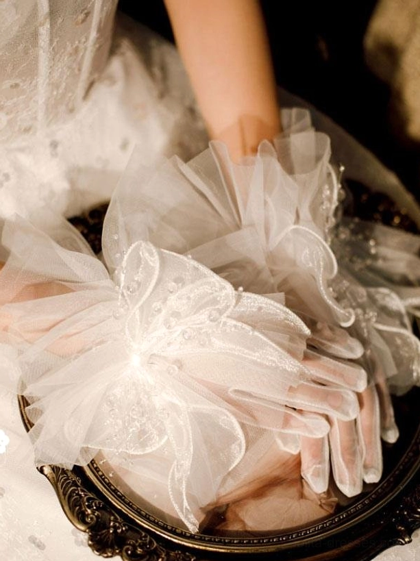 white tulle bow wedding gloves with puffy beaded rhinestone bow short sheer finger gloves model arm overhead close-up vintage setting