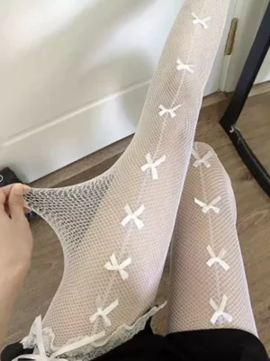 White vertical bowknot fishnet tights close-up lolita mesh pantyhose detail view with hand stretching lace trim