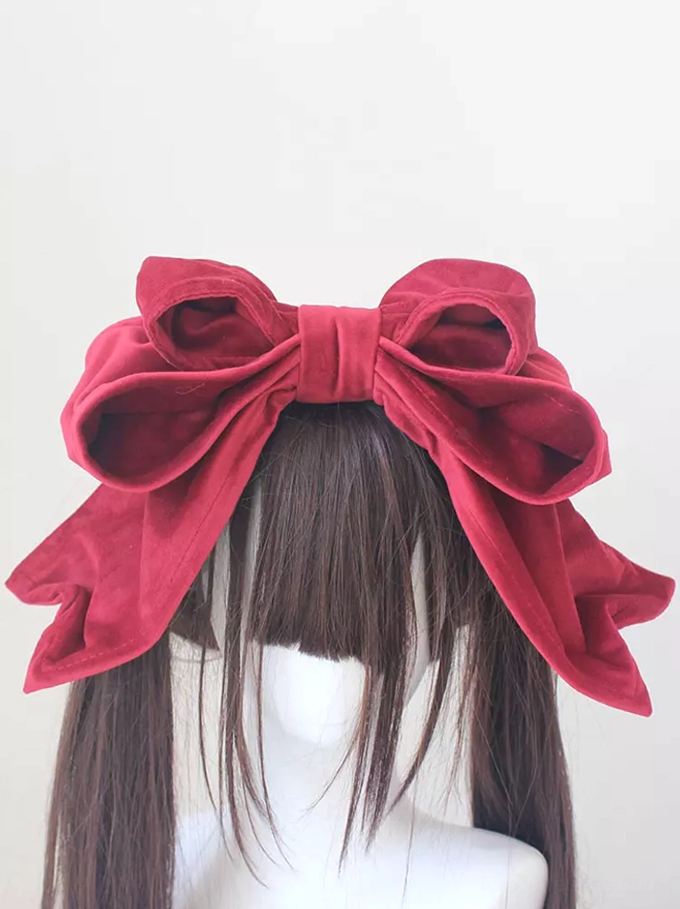 Wine red velvet Lolita headdress with oversized double bow design shown at eye level on straight-haired mannequin, displaying lace-up embellishment details and luxurious fabric texture