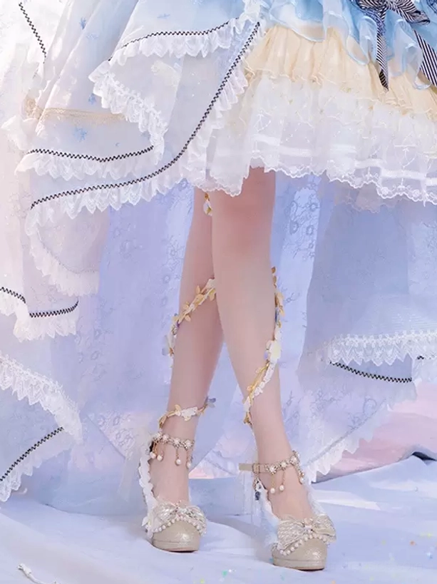 Champagne lolita pumps worn on feet with pearl tassel ankle straps, styled with frilly lolita gown, showcasing round toe and glitter upper