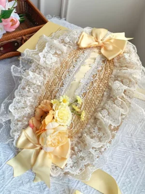 Yellow Sweet Lolita bonnet with cream lace ruffles and golden satin bow displayed on studio desktop with vintage lace fabric and wicker basket aesthetic